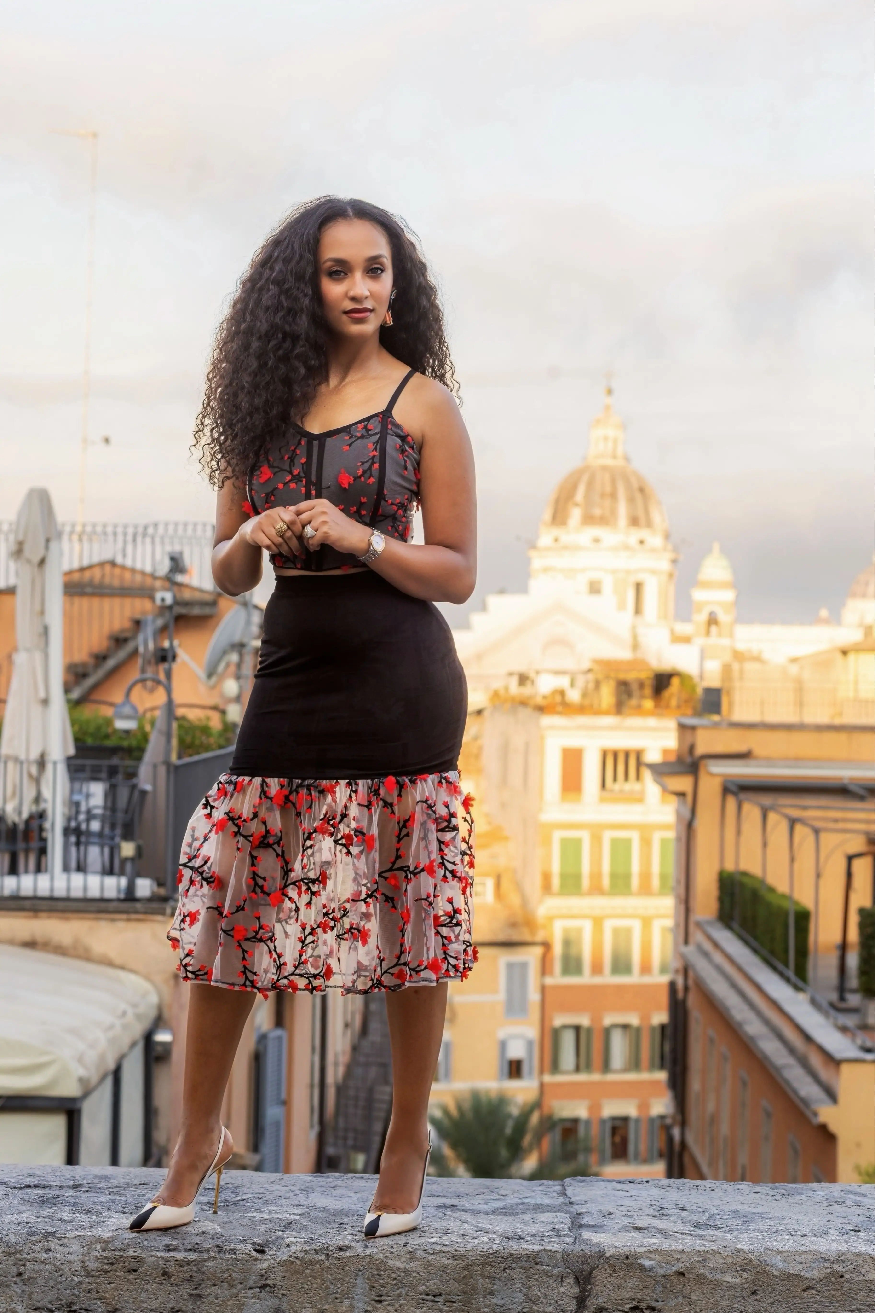 Model wearing Scarlet Romance against a rooftop view at golden hour